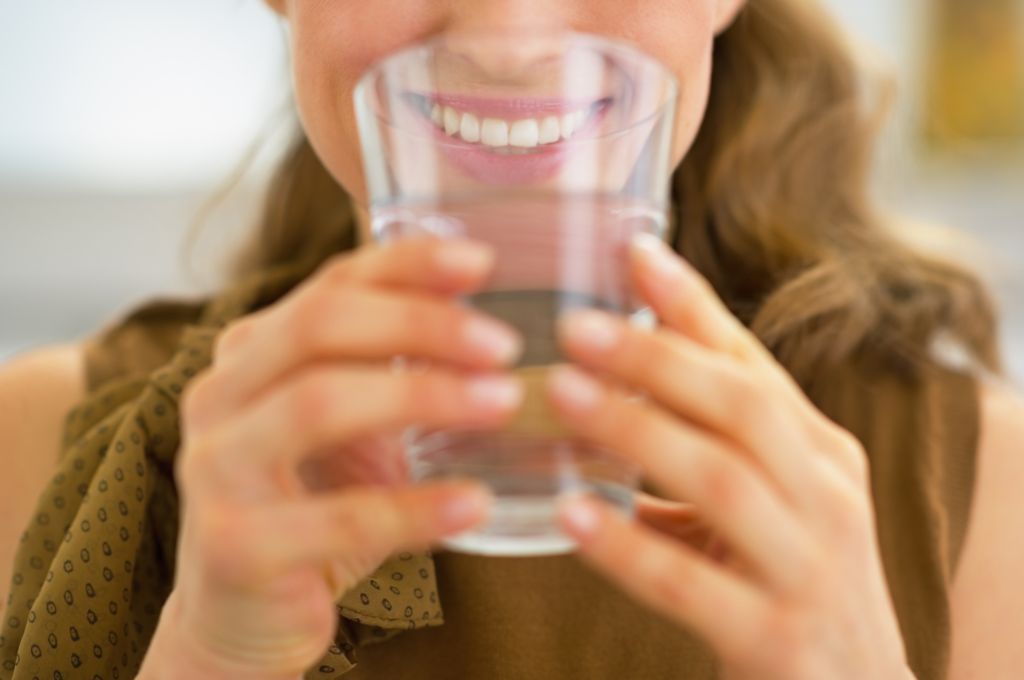  a woman holding a glass of water