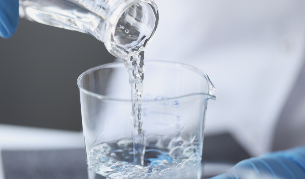 pouring liquid into a laboratory measuring cup